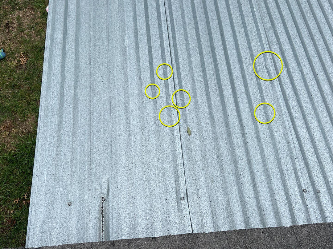 Hail strikes marked on a metal roofing panel